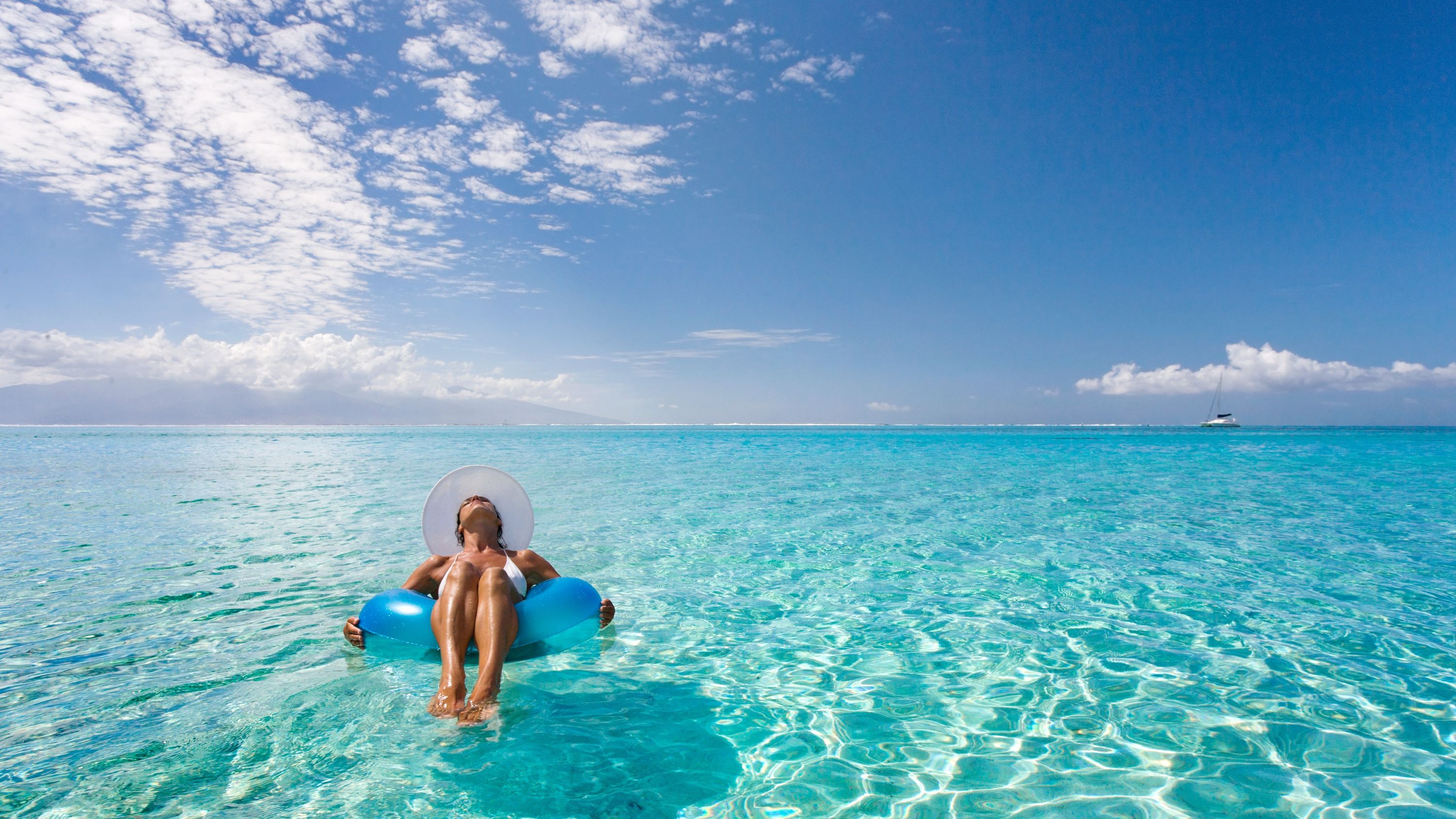 Frau entspannt auf dem Wasser unter tropischer Sonne | © Getty Images