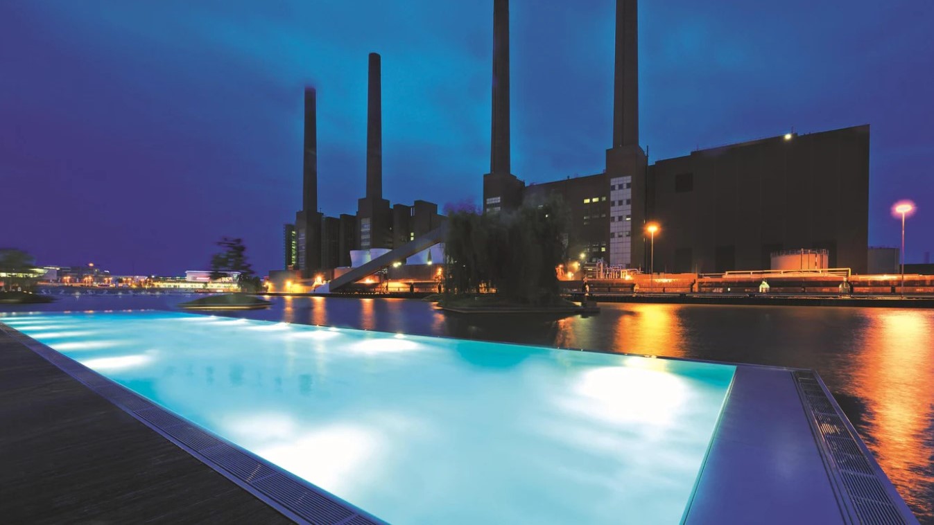 Der schwimmende Outdoor-Pool mit Blick auf die denkmalgeschützten Schornsteine des VW-Werks | © The Ritz-Carlton Wolfsburg
