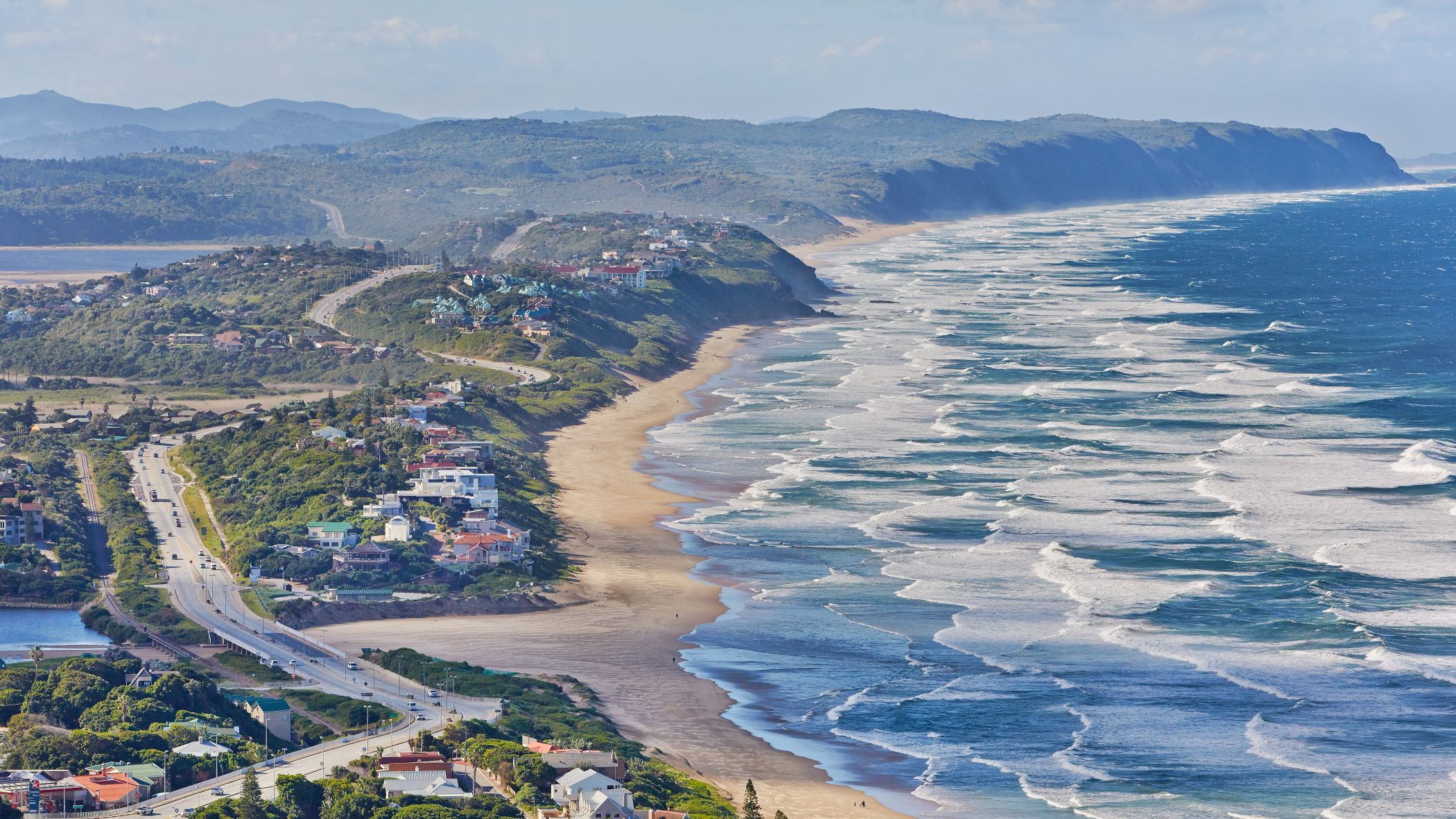 Strand bei der Stadt Wilderness entlang der Garden Route in Südafrika, mit sanften Wellen und Küstenlandschaft | © Getty Images